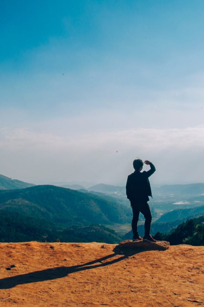 Silhouette of Man Standing on Mountain Cliff